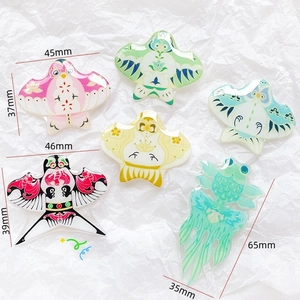 Flat lay of colorful acrylic Chinese kite and goldfish patches with UV printing detail