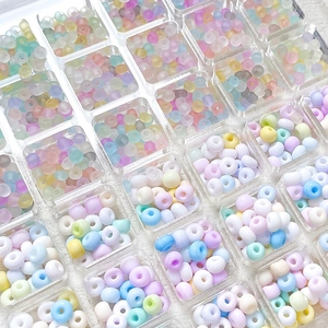 Mix of 3mm-4mm macaron glass beads organized in a clear compartment box for DIY jewelry