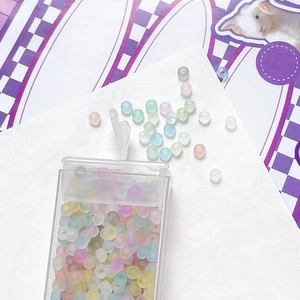 Macro view of macaron colored glass seed beads for DIY jewelry making in clear storage box