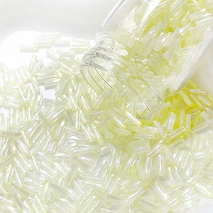 Detailed macro shot of 6mm cream iridescent glass bugle beads for DIY jewelry making