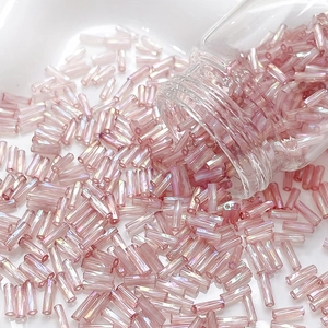 Detailed macro view of cream iridescent 6mm glass bugle beads for DIY jewelry making