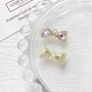 Detalle macro de colgantes de joyería en forma de lazo con cristales púrpuras y oro