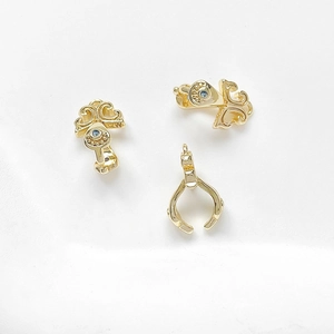 Detailed view of 18k gold plated jewelry clasps with vintage scroll patterns and blue gems