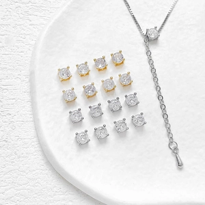 14k vergulde zirkonia oorbellen en ketting set op een wit keramisch dienblad