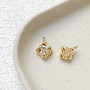 Close-up of 14k gold plated irregular lava frames with rectangular zircon pendants