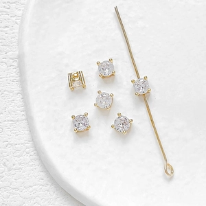 Macro-opname van vergulde 14k zirkoon kralen met vierklauw zetting voor DIY-sieraden maken