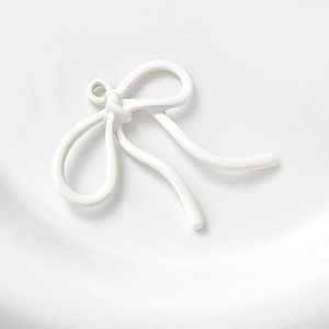 Detailopname van witte emaille strikhanger met metalen oogje voor DIY-sieraden