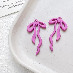 Dettaglio di ciondoli a fiocco in lega rosa opaco per creazione gioielli fai-da-te