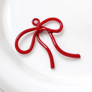 Detailopname van een rode strikhanger met emaille afwerking voor DIY-sieraden en ambachten