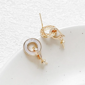 Detail showing 18k gold plated round stud earring with mother of pearl and zircon stones