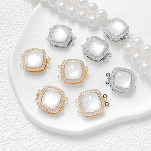 Detailed close-up of 14k gold plated white shell necklace clasps with paved zircons