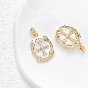 Detalle de dijes de cruz bañados en oro de 14k con circonitas blancas para hacer joyas