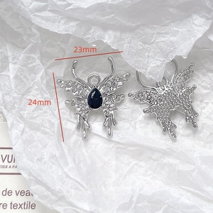 Detailed macro view showing the 23x24mm silver butterfly pendant with blue drop gemstone