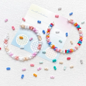 Close-up of handmade colorful macaron beaded earrings in pastel bow-shaped design