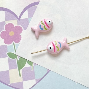 Detailed view of pink hand-painted fish beads with colorful stripes for DIY jewelry