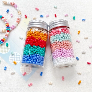 Colorful dumbbell-shaped glass seed beads for DIY jewelry making in glass jars