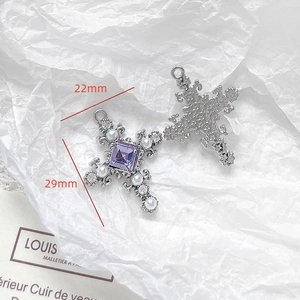 Detailed macro view of baroque cross pendant with purple crystal and white pearls