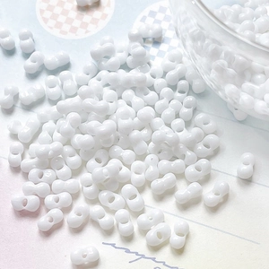 Macro shot of white peanut-shaped double-hole beads for DIY jewelry making and crafts