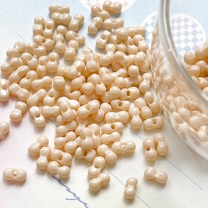 Macro shot of peanut-shaped cream resin beads for DIY jewelry and necklace making