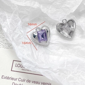 Detail of heart-shaped silver metal pendant with purple gemstone and 16mm size guide