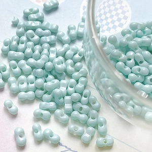 Close-up of mint green two-hole glass beads for DIY jewelry making and beadweaving