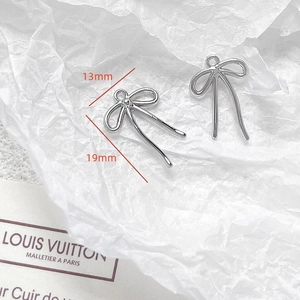 Macro view of silver bow charms for DIY jewelry with 13mm and 19mm size details