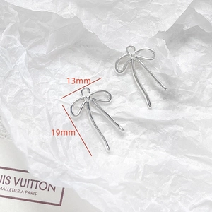 Detailed view of silver bow-shaped metal pendants with 13mm and 19mm size measurements