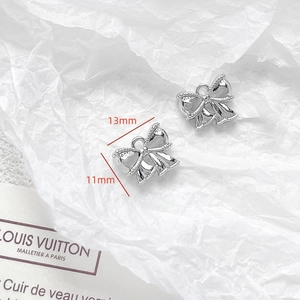 Macro shot of silver bow pendants for DIY jewelry with 13mm by 11mm size detail