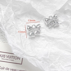 Detail of silver bow pendant showing precise 13mm x 11mm dimensions for DIY jewelry