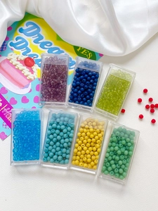 Macro detail of 4mm colorful glass seed beads set in organizer boxes for DIY jewelry