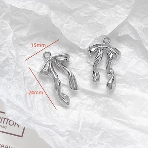 Detail of silver bow pendant with 15mm and 24mm dimensions on white background