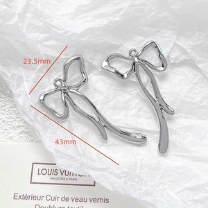Polished silver metal butterfly bow pendant measuring 43mm by 23.5mm with top hanging loop