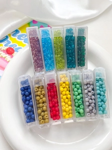 Macro detail of 4mm frosted glass seed beads in 12 color tubes for DIY jewelry making
