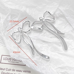 Silver bow-shaped metal pendants with hammered texture and 43mm height dimensions