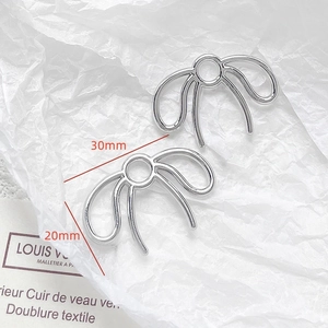Detailed view of silver bow-shaped DIY jewelry charms with 30mm x 20mm dimensions