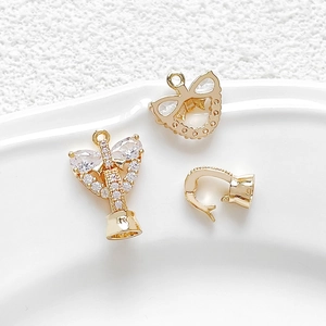 Vue macro de breloques nœud et ange plaquées or 18 carats avec oxydes de zirconium