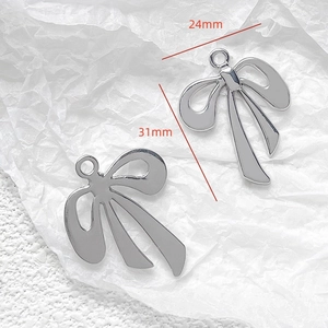 Detailed close-up of 24x31mm silver metal bow charms for DIY jewelry making