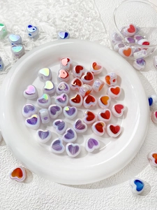 Close-up of colorful heart-shaped acrylic beads with metallic gloss for DIY jewelry making