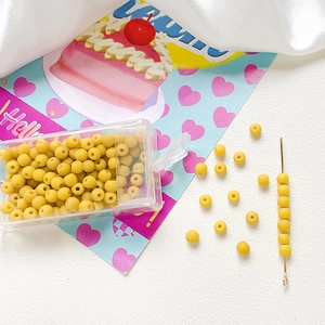 Macro shot of 4mm frosted yellow glass beads in a storage box for DIY jewelry making