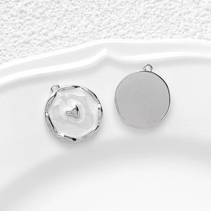 Détail macro d'un pendentif cœur rond argenté avec émail blanc et anneau de suspension
