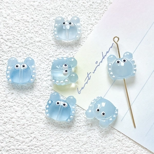 Close-up of light blue cartoon crab charms with white dots for DIY jewelry making