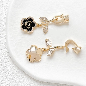 Detailed macro shot of 18k gold plated camellia flower charms with zircon and lobster clasps