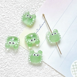 Macro detail of cute green glass crab beads with white polka dots for DIY jewelry making