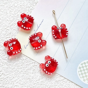 Macro detail of red glass crab beads with white polka dots for DIY jewelry making