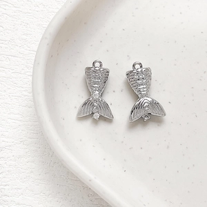 Makroaufnahme von silbernen Zirkon-Meerjungfrauenschwanz-Anhängern für DIY-Schmuck
