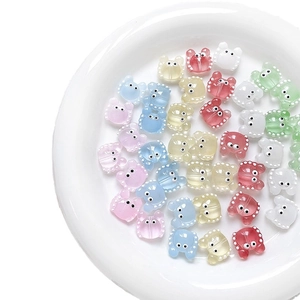 Colorful translucent cartoon crab charms for DIY jewelry making in a white ceramic dish