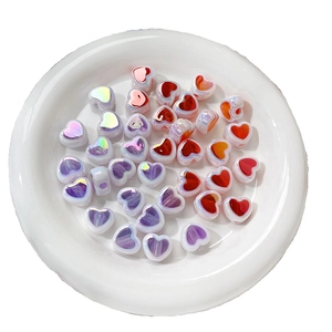Mix of colorful acrylic heart beads in a white tray for DIY jewelry making and crafts