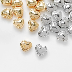 Polished 14k gold and silver heart-shaped spacer beads with milgrain edges for DIY jewelry