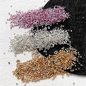 Macro shot of metallic cylinder seed beads in pink, silver and bronze for DIY jewelry making