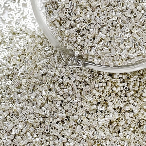 Macro shot of silver cylindrical glass seed beads for DIY jewelry and embroidery crafts